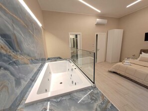 A modern bathroom with a marble vanity, a glass-enclosed bathtub, and a walk-in shower. - B&B POMPEI CENTER LUXURY VIA ROMA (Pompei)