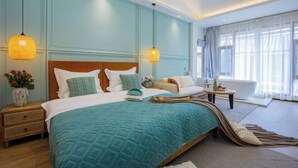 A bedroom with a large bed, two bedside tables, a nightstand, a window with curtains, and a hanging light fixture. - The Valley of Flowers (Lijiang)