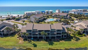 Un hotel de varios pisos con piscina, cerca de una masa de agua y una playa.