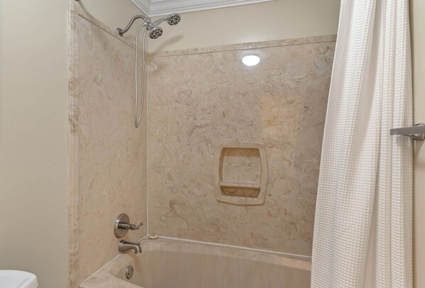 Un baño con ducha, inodoro y bañera.