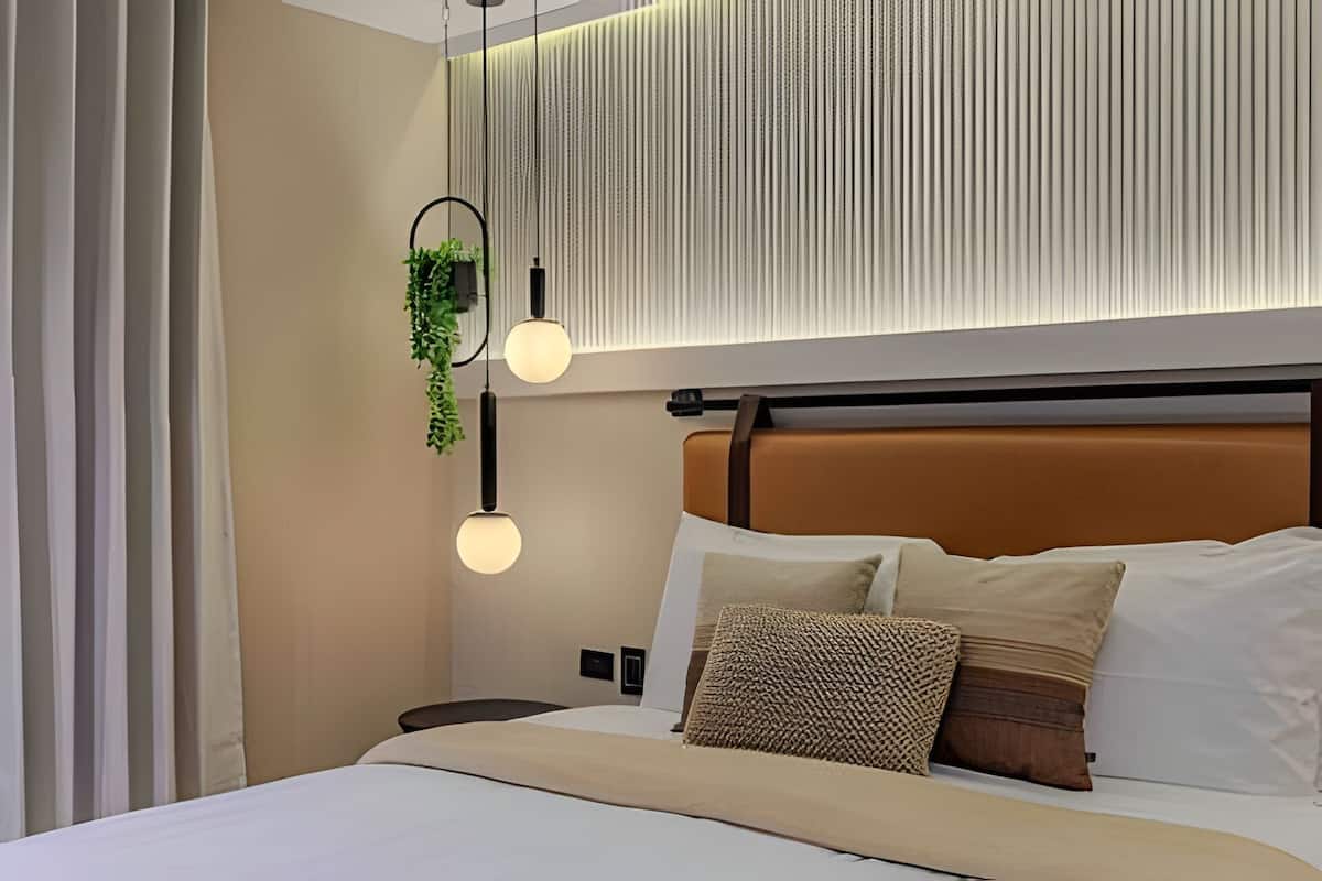 A modern bedroom with a bed, a nightstand, and a wall-mounted plant.