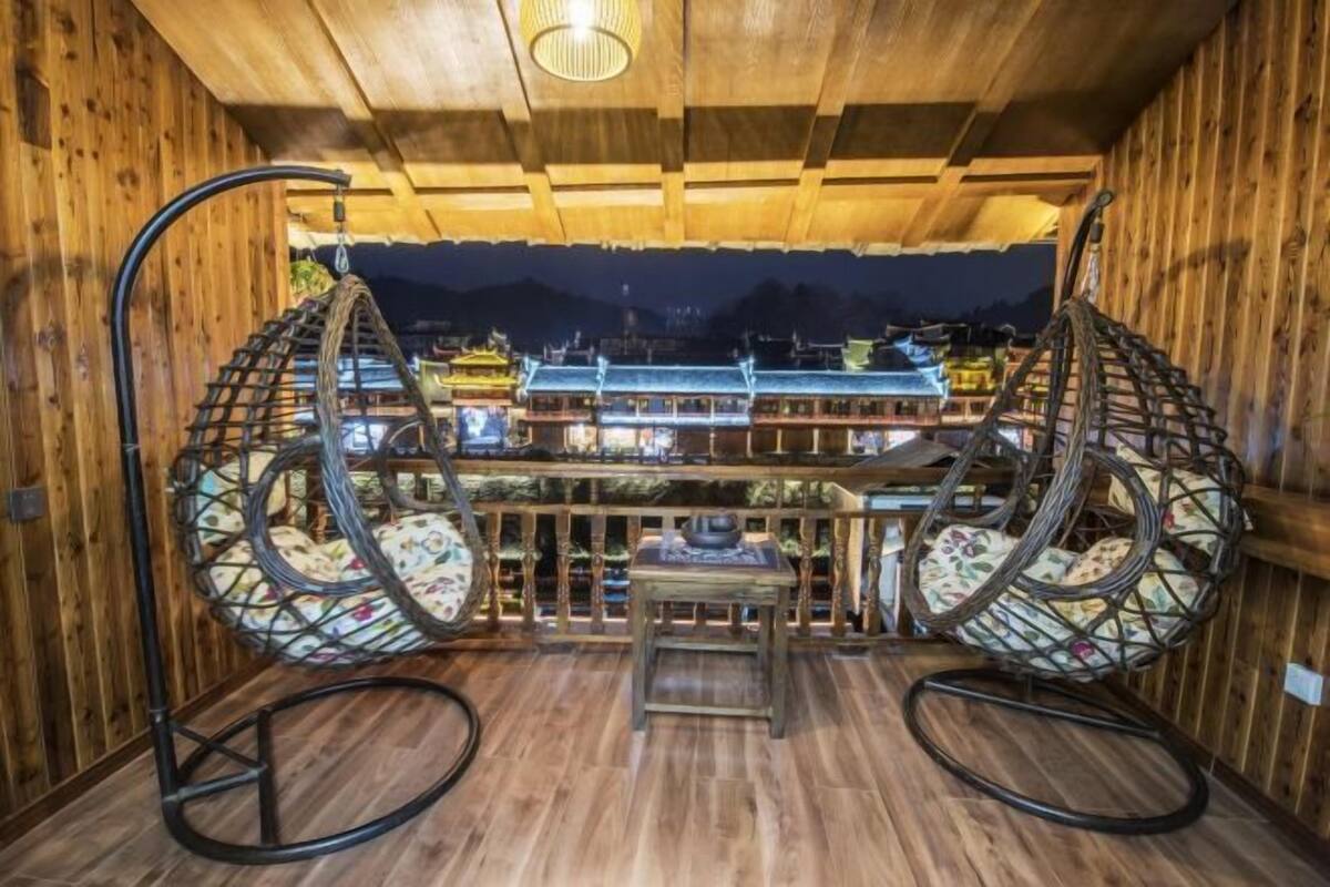 Interior de madeira com uma cadeira suspensa tradicional e uma pequena mesa.