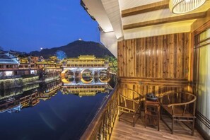 Enjoy a tranquil evening on the balcony with a view of the hotel's serene reflection in the water.