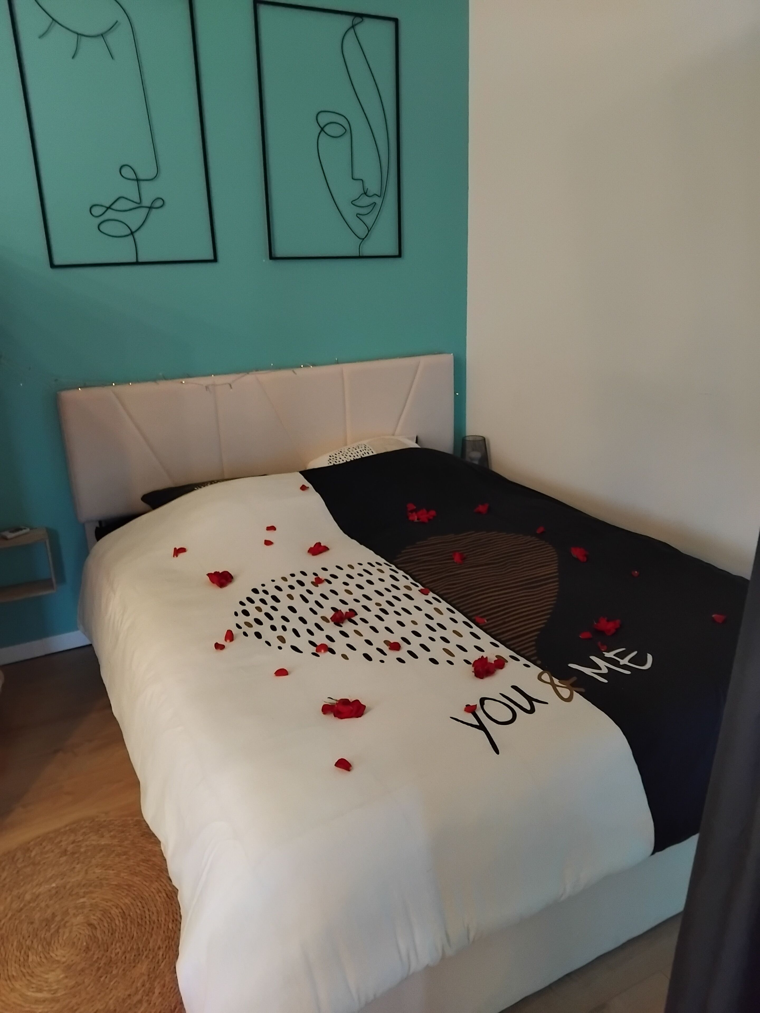 Una camera da letto con un letto, una testiera e due opere d'arte appese alle pareti.