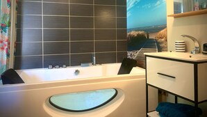Un baño con bañera, lavabo y espejo.