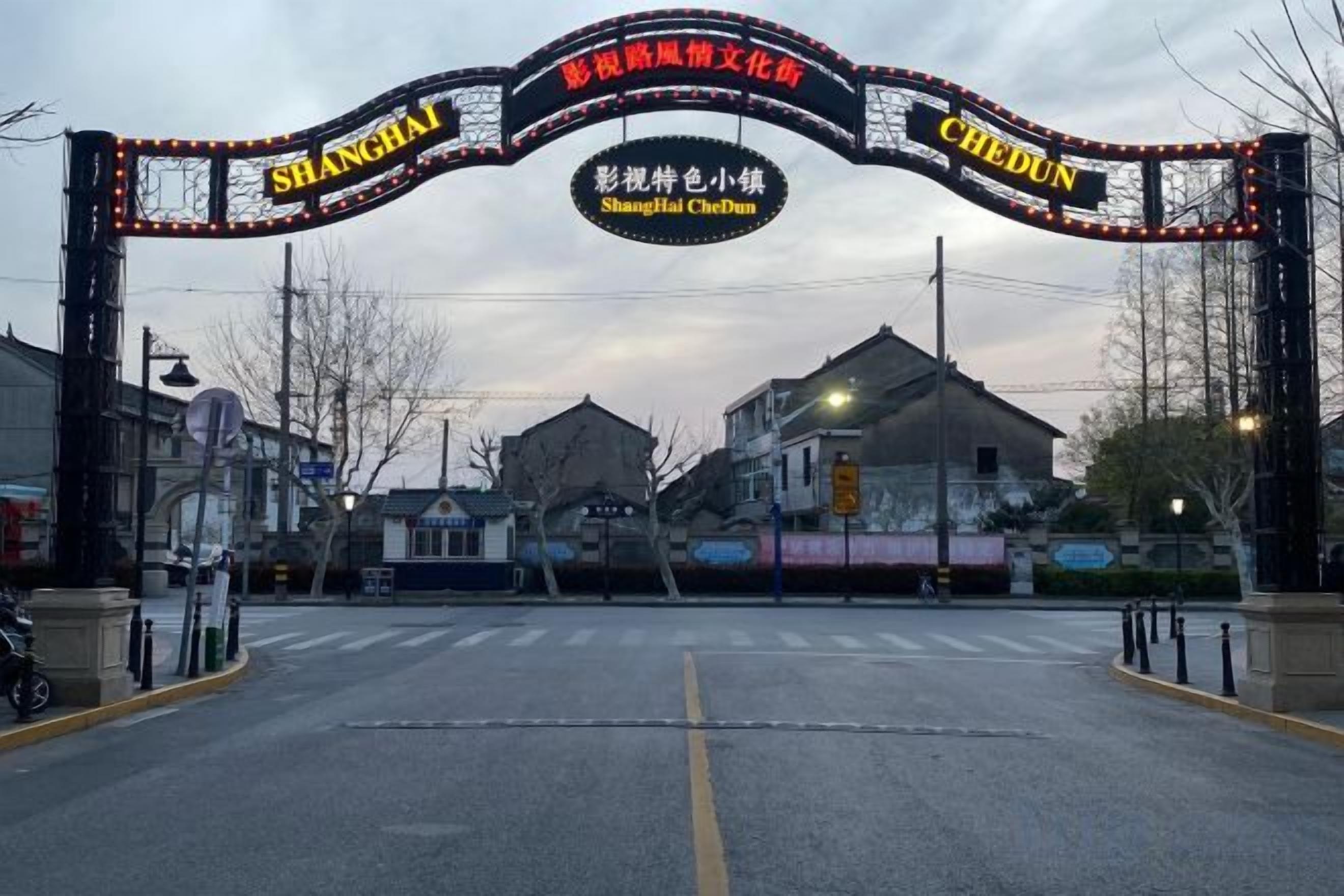 Una entrada a la calle con un letrero que dice 'Shanghai CheDuN'.