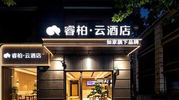 A hotel entrance with a modern design, featuring a prominent sign and a welcoming entrance.