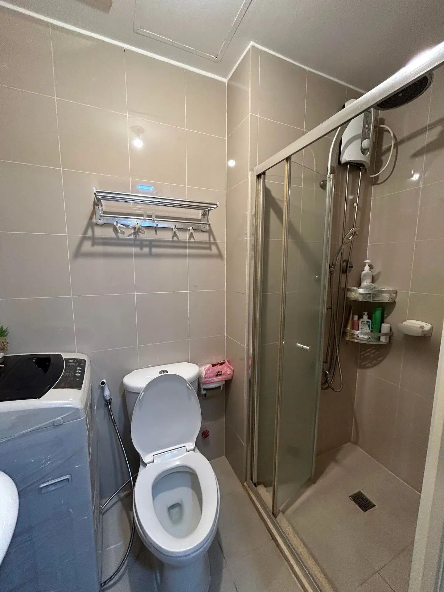 Une salle de bain comprenant des toilettes, un espace douche et un lavabo.