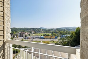 A balcony with a view of a town, including buildings and a road. - 1 BR | Whispering Pines Resort | Indoor Pool | Mtn & Pigeon Forge View (Pigeon Forge)