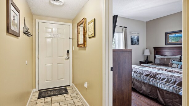 A hotel room with a bed, a nightstand, a lamp, and a painting on the wall.