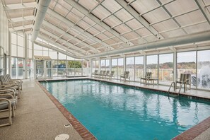A swimming pool with a covered area, lounge chairs, and a view of the outdoors. - 2 BR | Indoor Pool | Hot Tub Access | Mtn View (Pigeon Forge)
