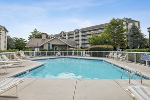 A swimming pool with lounge chairs and a no diving sign.