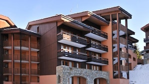 Un immeuble à plusieurs étages, doté de balcons et d’une arche en pierre.