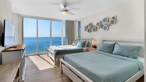 A hotel room with a large bed, a smaller bed, a desk with a TV, and a view of the ocean. - LAGOON POOL OPEN!! TOTAL REMODEL! THREE BEDROOM AT LONG BEACH (Panama City Beach)