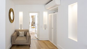 A modern interior with a sofa, a mirror, and a wardrobe. - Townhouse in Tavira With 2 Bedrooms and 2 Bathrooms (Tavira)