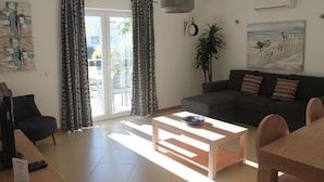 Een moderne woonkamer met een bank, een salontafel en een eethoek.
