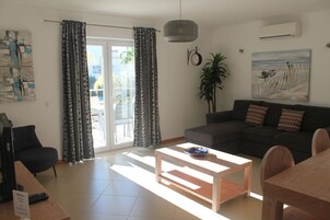 Uma sala de estar moderna com sofá, mesa de centro e área de jantar.