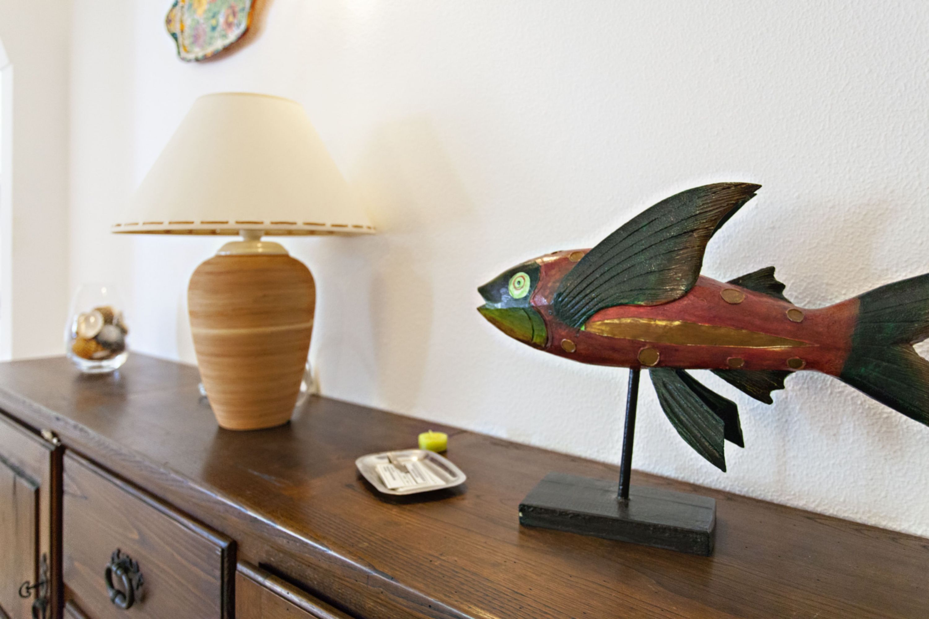 Ein Holzkasten mit einer Lampe, einem kleinen Dekorationsfisch und einer Kerze.