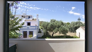 A view from a window overlooking a building with a tiled roof and a balcony. - Cabanas Village in Tavira (Tavira)