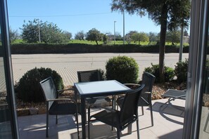 Enjoy al fresco dining on the patio with a glass door leading to a serene outdoor space.