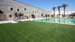 Un bâtiment doté d’une façade en pierre et d’une piscine.