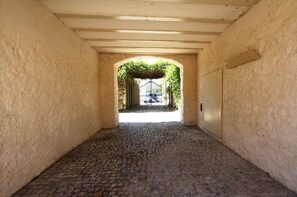A cobblestone corridor with a wooden ceiling and a door on the right. - CV C - Salinas - Convento das Bernardas (Tavira)