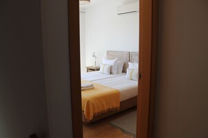 Un dormitorio con una cama, una mesita de noche y una lámpara.