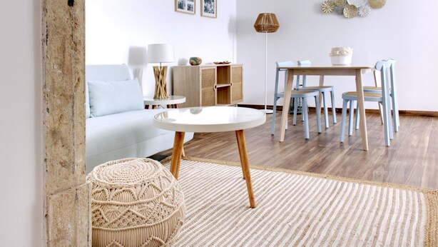 A modern living room with a round table, a sofa, and a dining area with chairs. - S qua - Apt do Rio (Tavira)