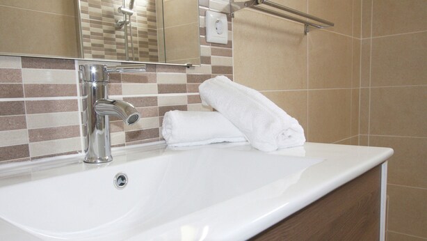 A bathroom with a white sink, a mirror, and a towel. - Jara in Tavira With 3 Bedrooms and 1 Bathrooms (Tavira)