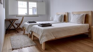 Une chambre avec deux lits, un bureau et une fenêtre.
