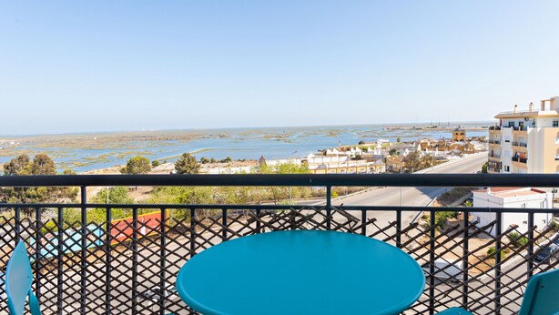 A balcony with a view of a coastal town, a road, and a body of water. - Formosa View in Faro (Faro)