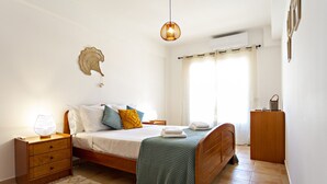 A bedroom with a bed, bedside table, lamp, and a wall decoration. - Cabanas Vintage in Tavira (Tavira)