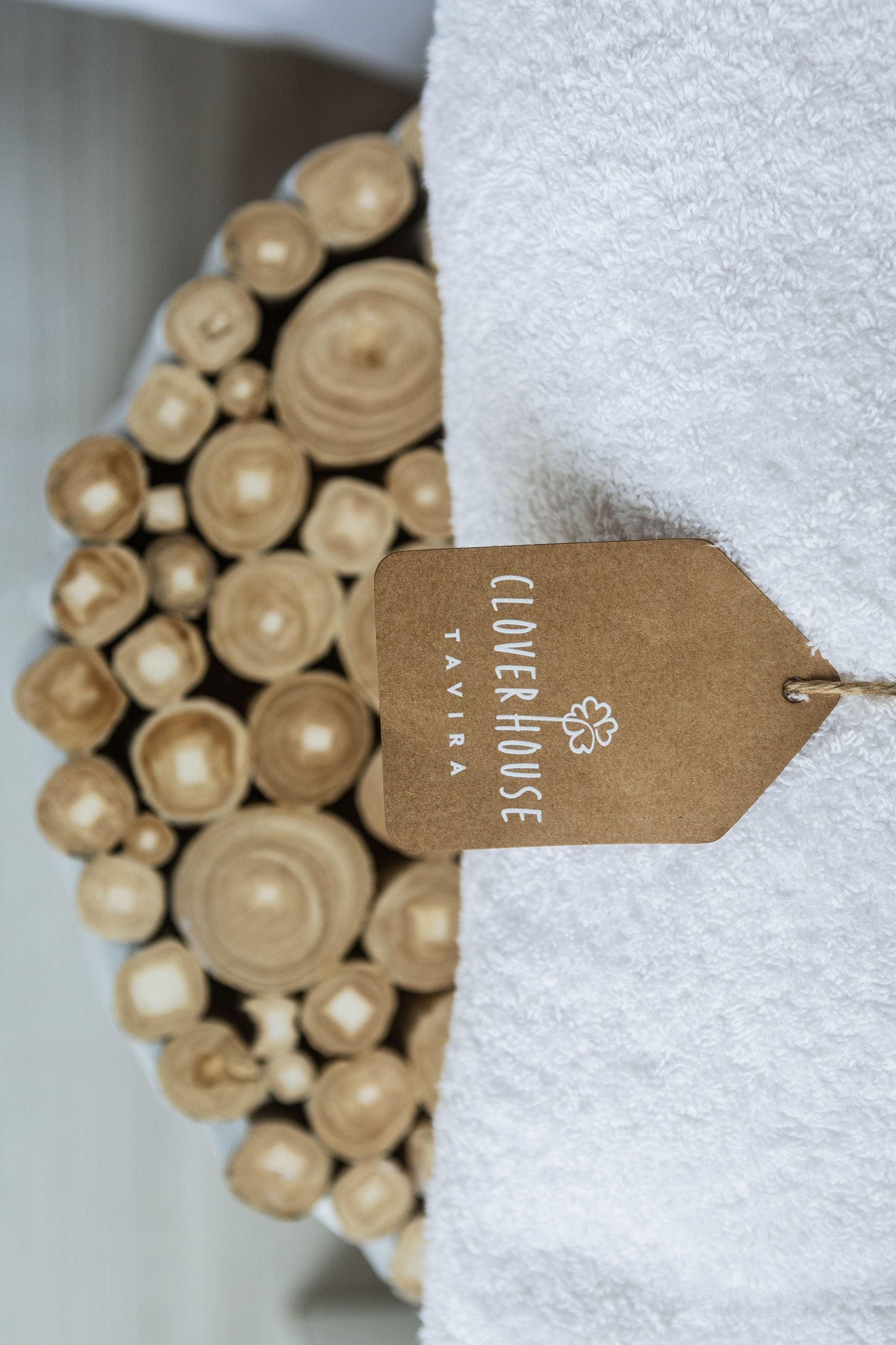 Een label met de tekst 'Clover House Tayra' aan een witte handdoek.