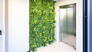 A modern elevator with a metallic finish and a wall adorned with a dense, green vertical garden. - My Ocean View in Tavira (Tavira)