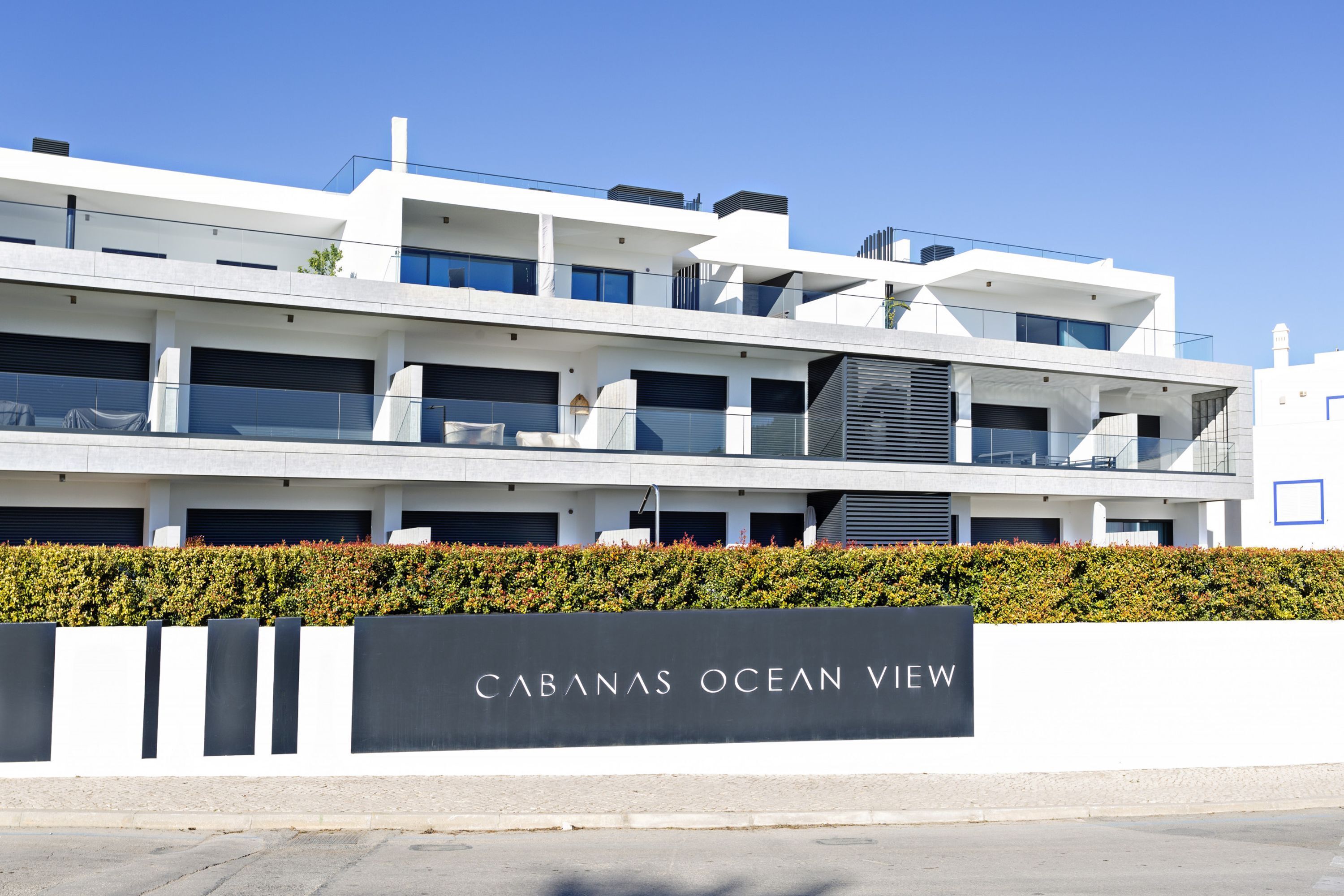 Un hotel moderno de varios pisos con un letrero llamativo que dice "CABANAS OCEAN VIEW".