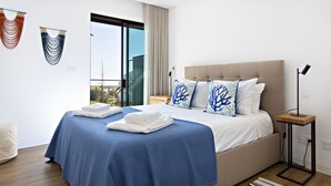 A modern hotel room with a large bed, a view of the city, and a balcony. - My Ocean View in Tavira (Tavira)