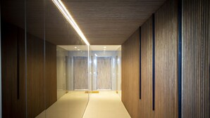 A modern hallway with wooden paneling, glass doors, and recessed lighting. - My Ocean View in Tavira (Tavira)