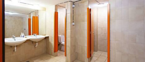 A bathroom with two sinks, a toilet, and a shower area.