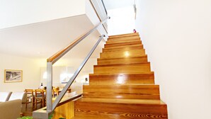 A wooden staircase with a metal handrail leading to a landing. - CV AR- Convento das Bernardas (Tavira)