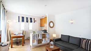 Una sala de estar moderna con un sofá, una mesa de centro y un comedor con sillas y una mesa.