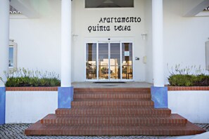 A building entrance with a sign reading "Apartamento Quinta Veira" and a set of steps leading up to it. - QV 210 - Black White Apartment - Quinta Velha (Tavira)