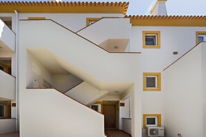 Ein mehrstöckiges Gebäude mit Treppe und mehreren Fenstern.
