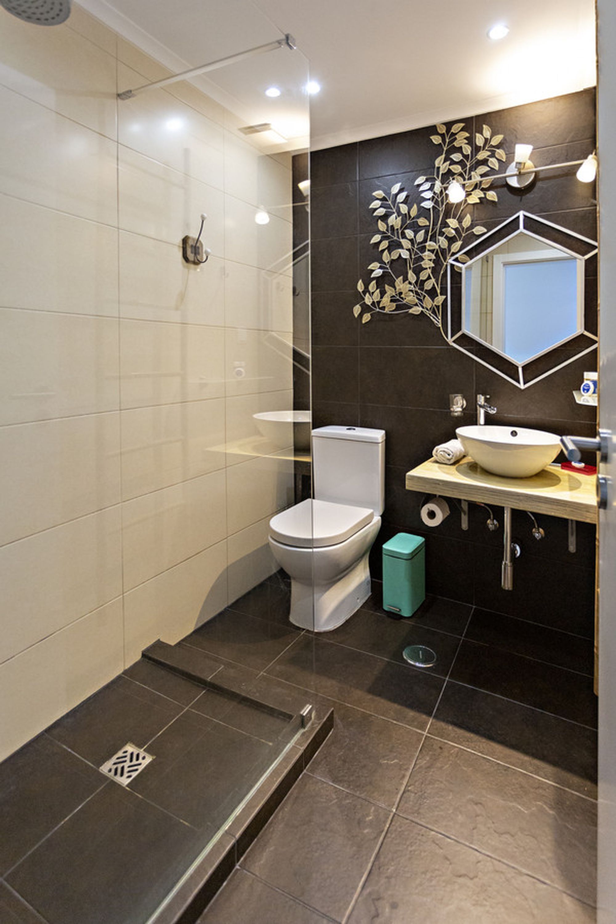 A modern bathroom with a toilet, sink, and shower.