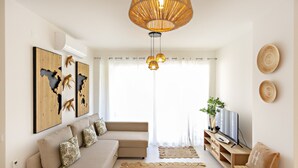 Un salon avec un canapé, une télévision et des objets de décoration.