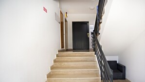 A staircase with beige steps leading to a dark door at the top. - CB Miranda - Cabanas Beach (Tavira)