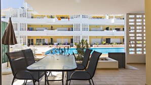 An outdoor patio with a pool, lounge chairs, and a table. - CB Miranda - Cabanas Beach (Tavira)