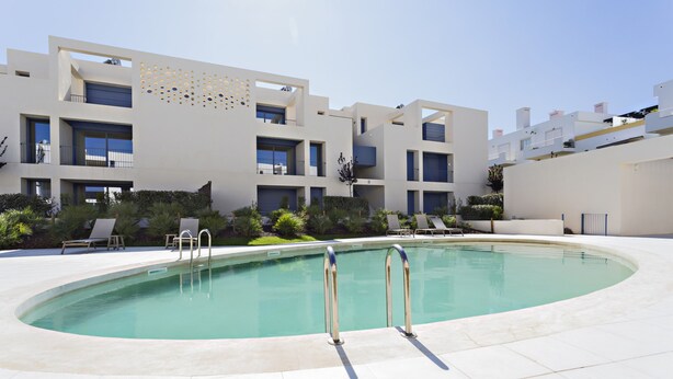 A modern building with a pool, outdoor seating, and a clear sky. - Casas do Forte BE in Tavira (Tavira)