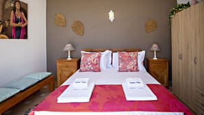 A neatly arranged bedroom with a bed, two bedside tables, a bench, and a wardrobe.