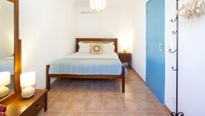 Una camera da letto con un letto, comodini, una lampada a sospensione e un armadio.