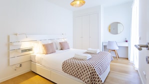 A modern bedroom with a white bed, bedside tables, a desk, and a chair. - Casas do Forte EF - Casa de Cabanas (Tavira)